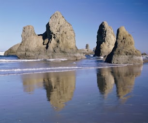 uma praia com algumas pedras na água