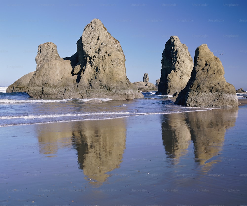 Una playa con algunas rocas en el agua