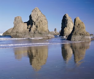 a beach with some rocks in the water