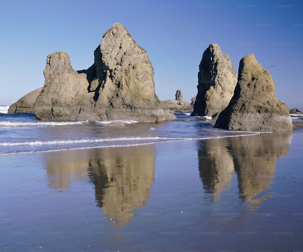 a beach with some rocks in the water