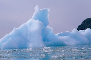 a large iceberg floating in the middle of the ocean