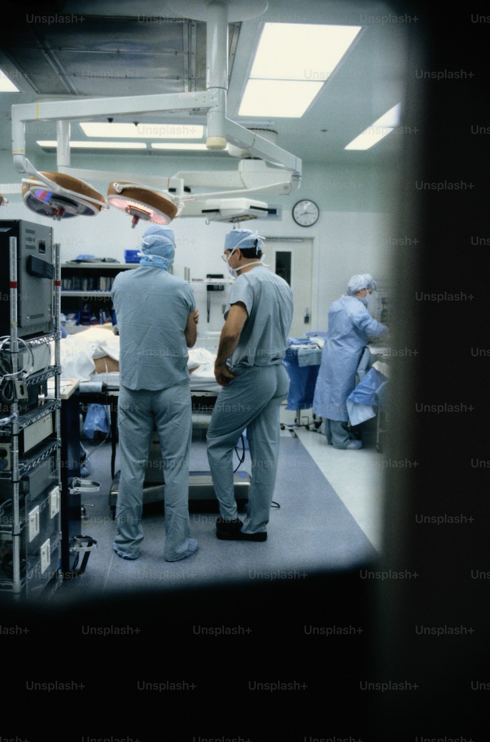 Eine Gruppe von Ärzten, die um ein Krankenhauszimmer herum stehen