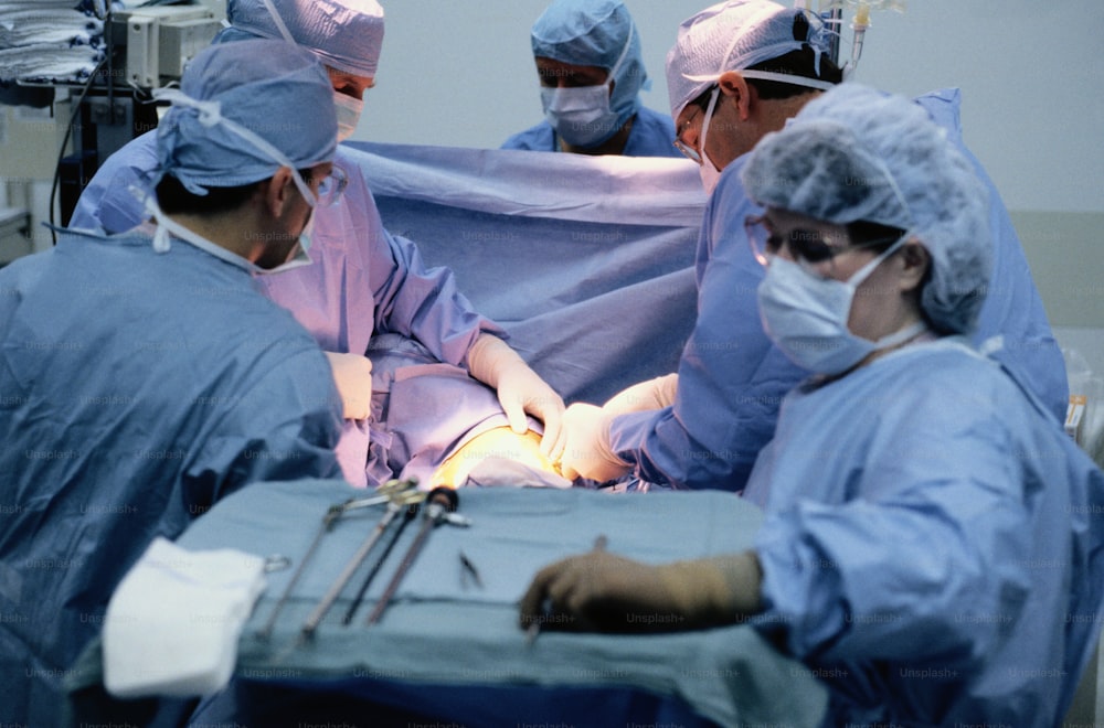 eine gruppe von ärzten, die operationen in einem operationssaal durchführen