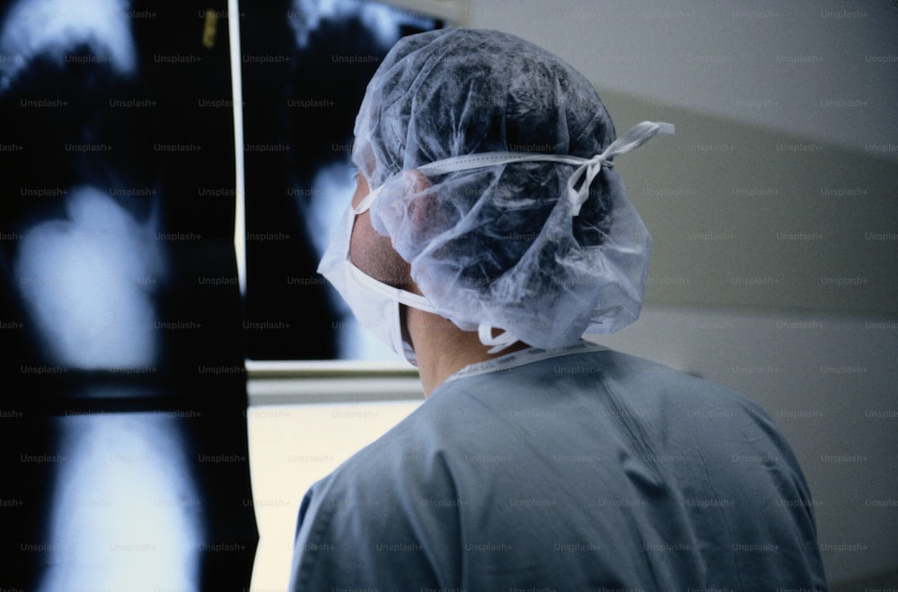 a person with a plastic covering on their head looking at an x - ray
