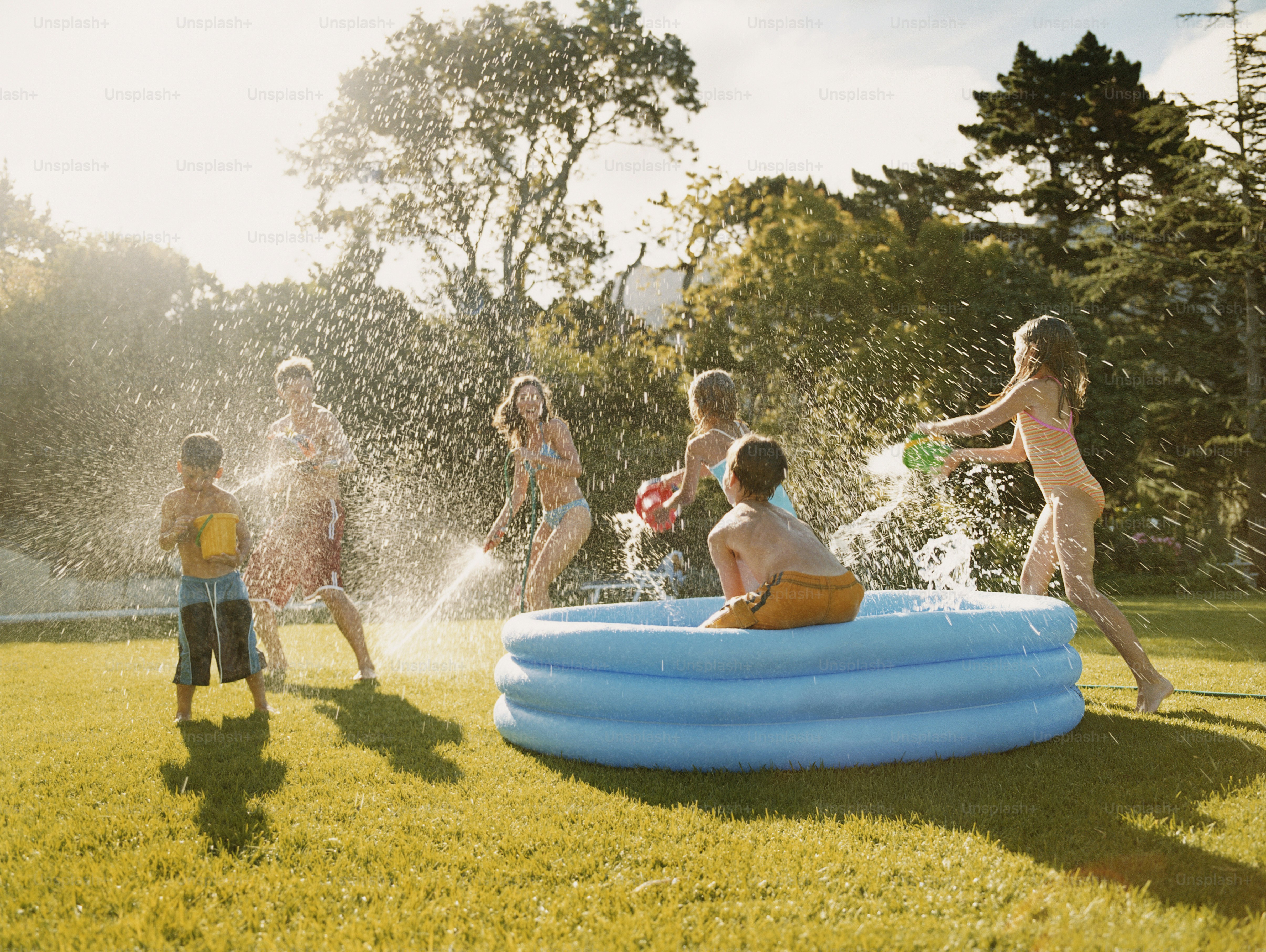 a group of children playing in an inflatable pool