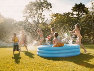 um grupo de crianças brincando em uma piscina inflável