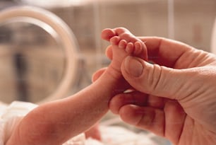 a close up of a person holding a baby's foot