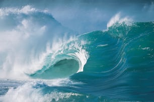 a large wave crashing into the ocean on a sunny day