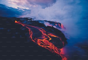 a lava flow in the ocean with a mountain in the background