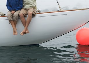 a man and a woman sitting on a boat in the water