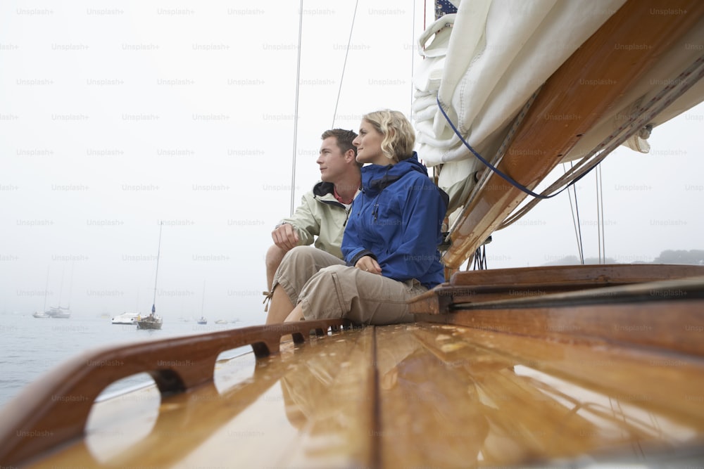 un uomo e una donna seduti su una barca a vela