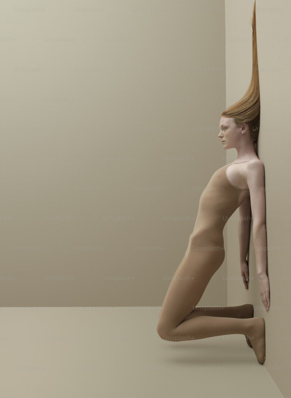 Une femme nue est appuyée contre un mur