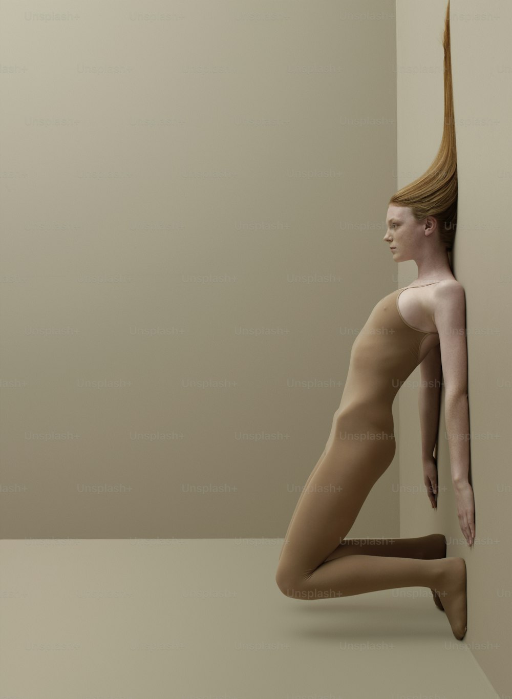 a nude woman is leaning against a wall