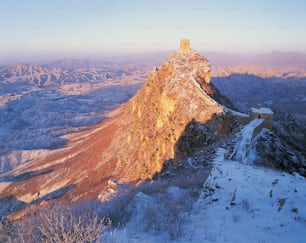 uma montanha coberta de neve com uma torre no topo dela