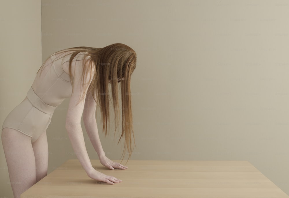 a woman bending over on top of a wooden table