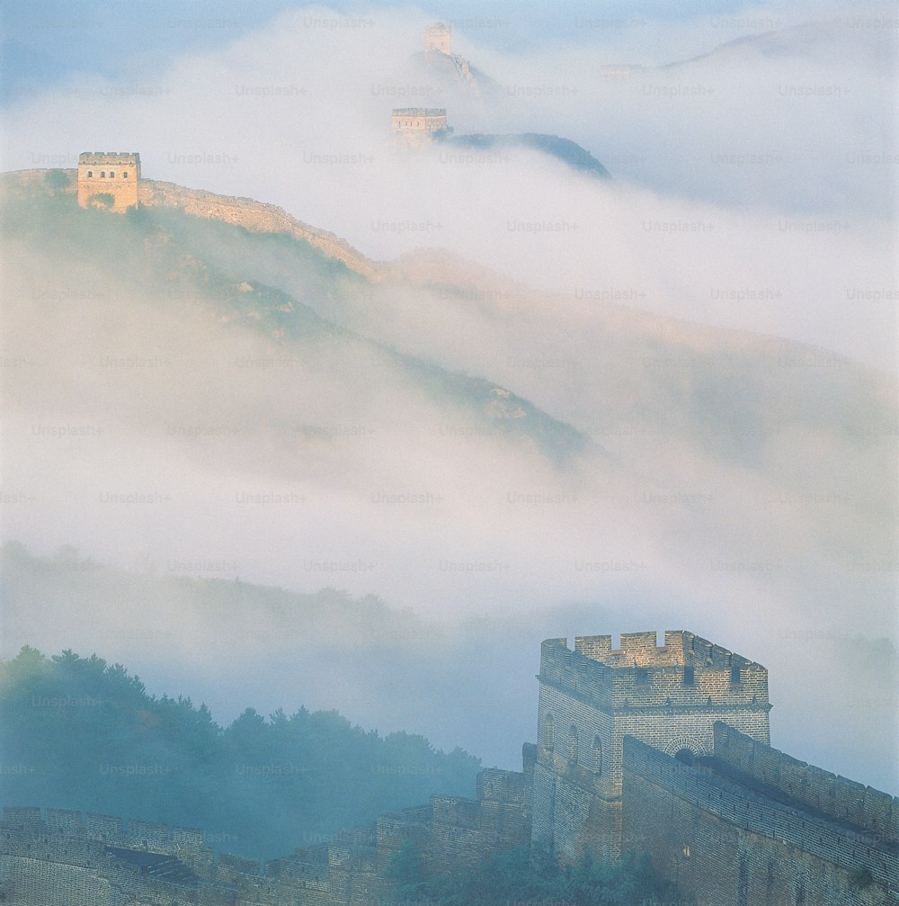 um castelo no topo de uma colina cercada por nevoeiro