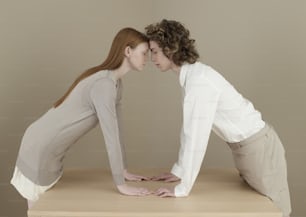 a man and a woman touching noses on a table
