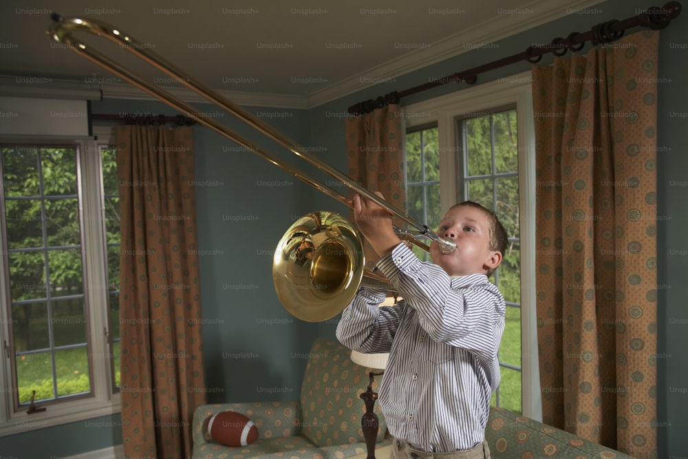 a young boy playing a trombone in a living room