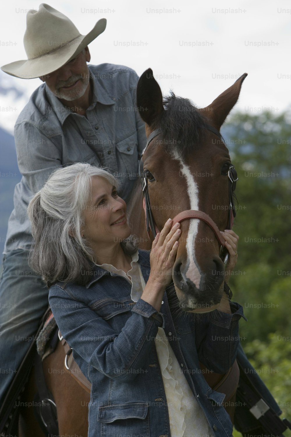 a man and a woman are petting a horse
