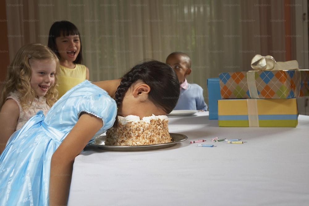 a young girl blowing out candles on a cake