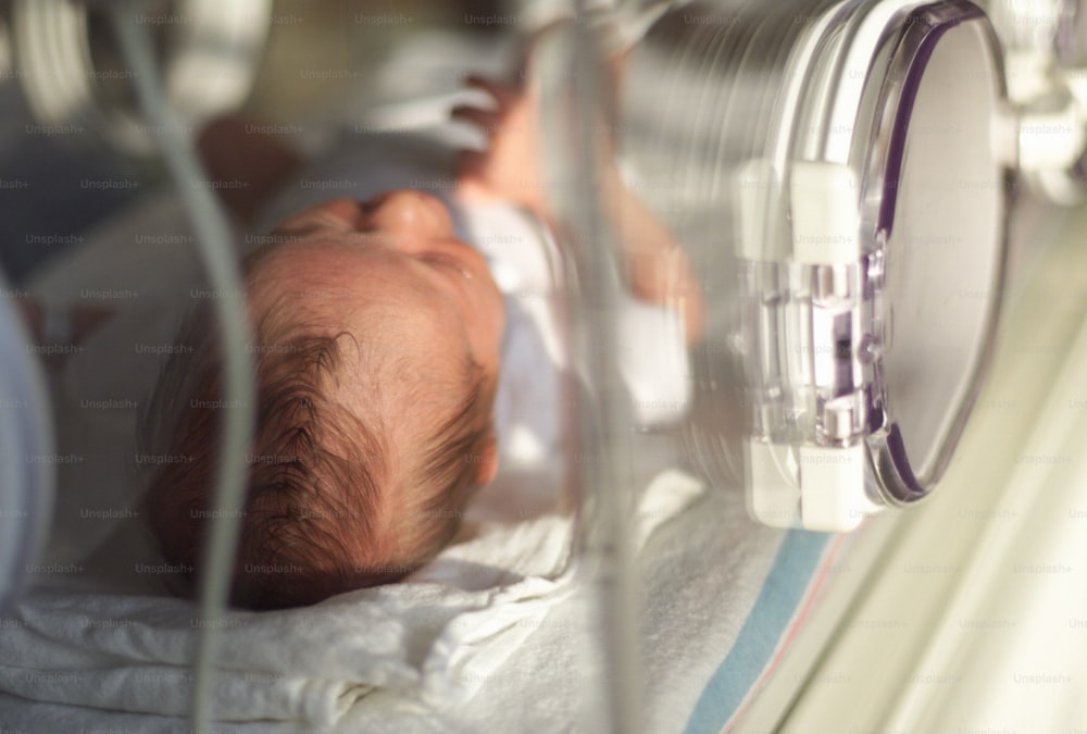 a baby laying in a crib in a hospital