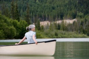 a woman sitting in a canoe on a lake