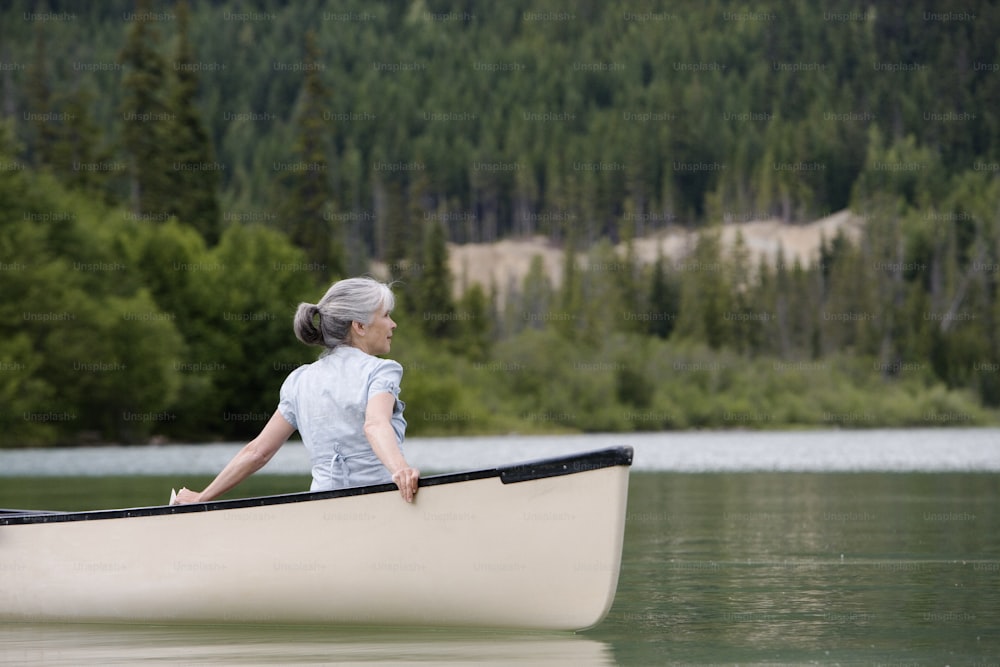 a woman sitting in a canoe on a lake