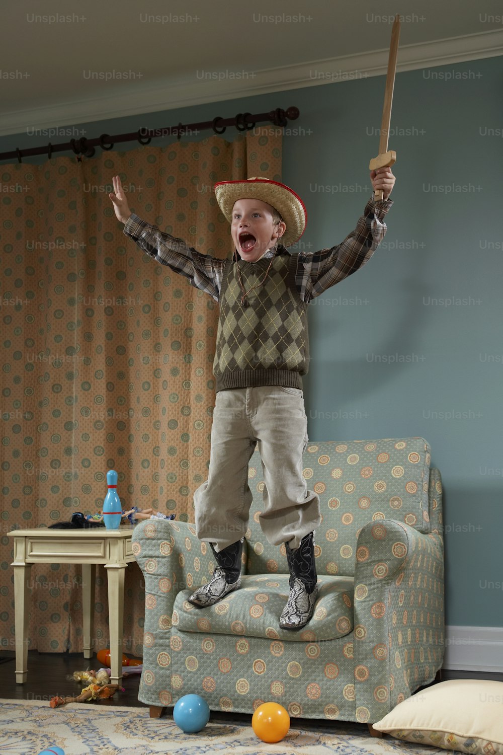 Un jeune garçon saute sur un canapé