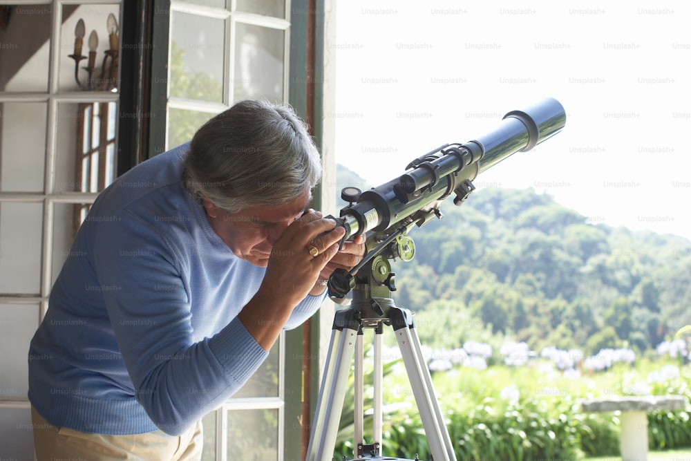 an older woman looking through a telescope
