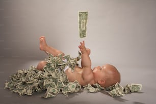 um bebê deitado de costas em uma pilha de dinheiro