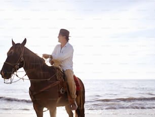 una donna che cavalca un cavallo sulla spiaggia