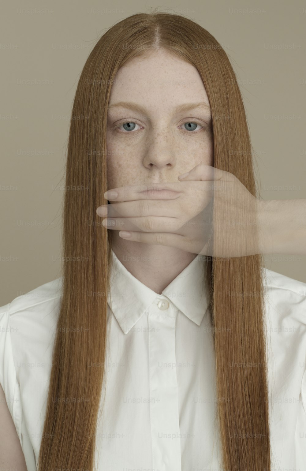 a woman with long red hair covering her face with her hands