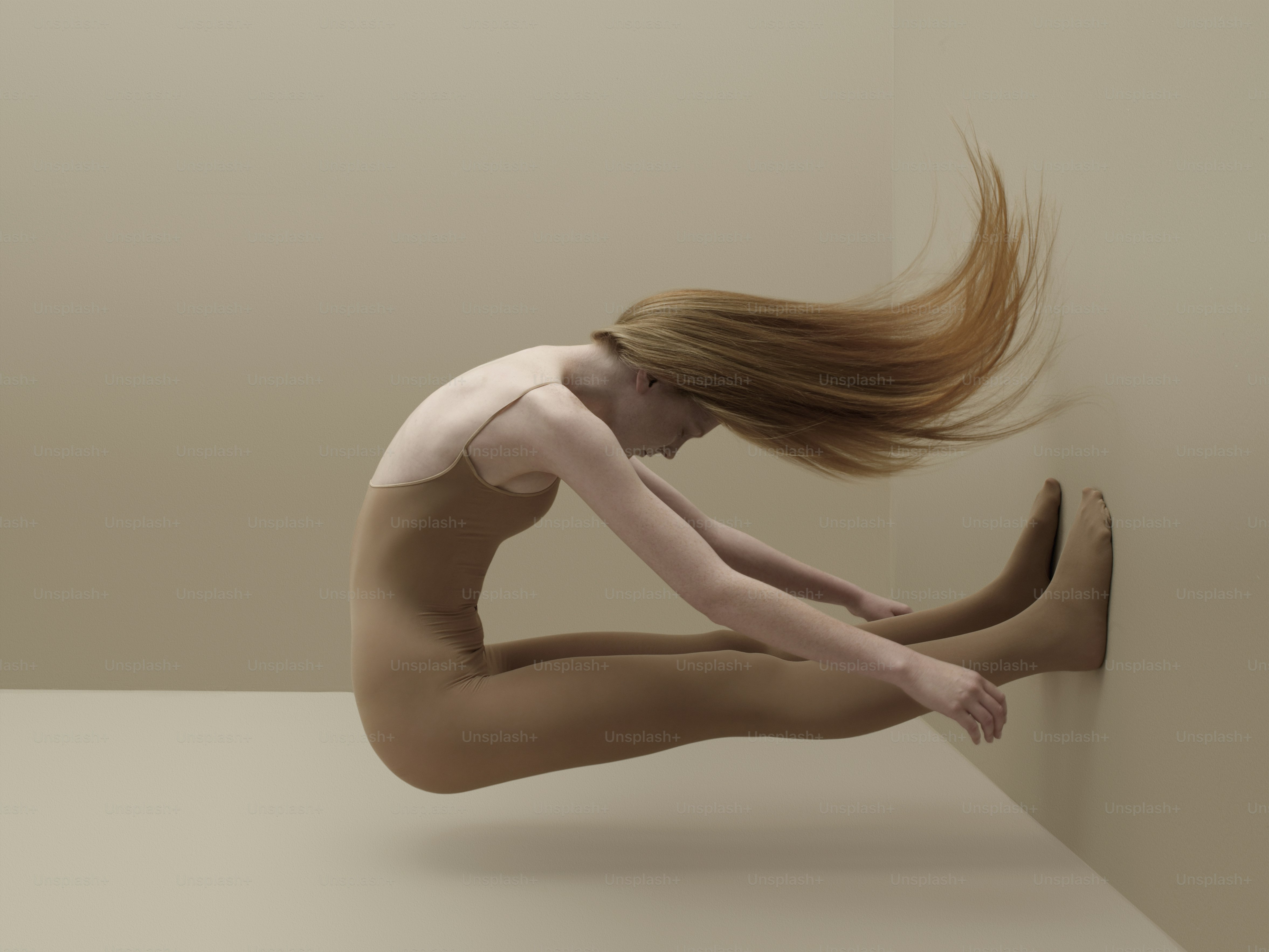 Una donna nuda è appoggiata a un muro