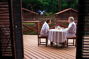two women sitting at a table on a deck