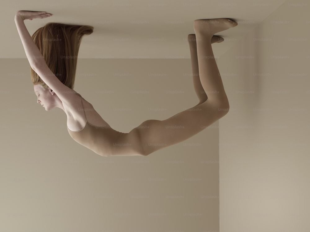 uma mulher nua pendurada de cabeça para baixo de um teto