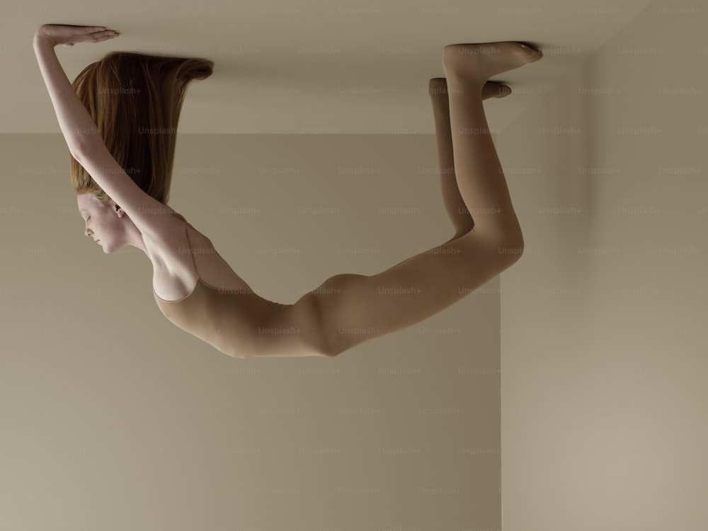 a naked woman hanging upside down from a ceiling