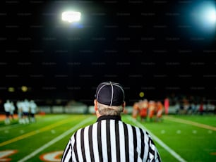 a referee standing on a football field at night