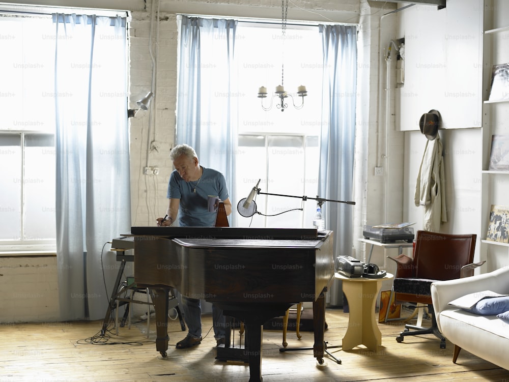 um homem tocando um piano de cauda em uma sala de estar