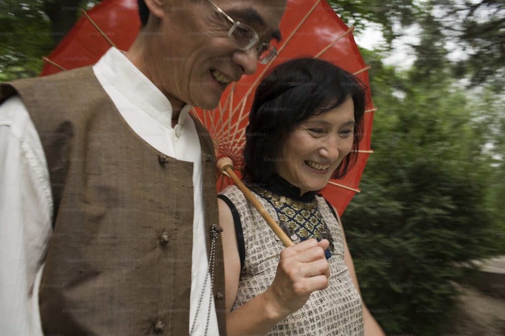 a man and a woman smile as they hold an umbrella