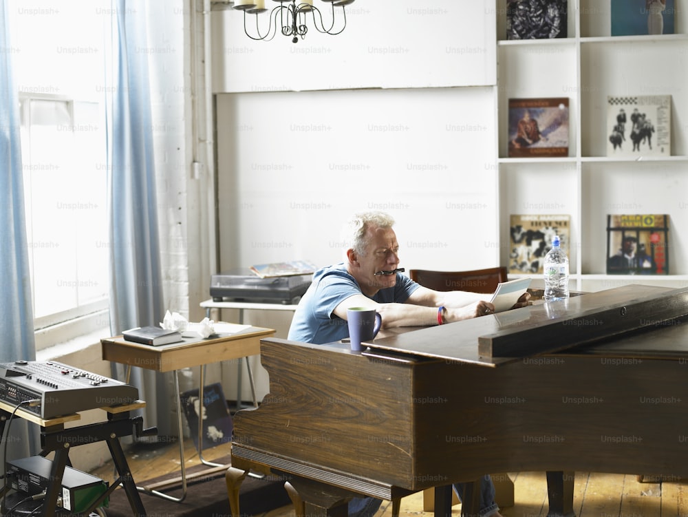 um homem sentado em um piano em uma sala de estar