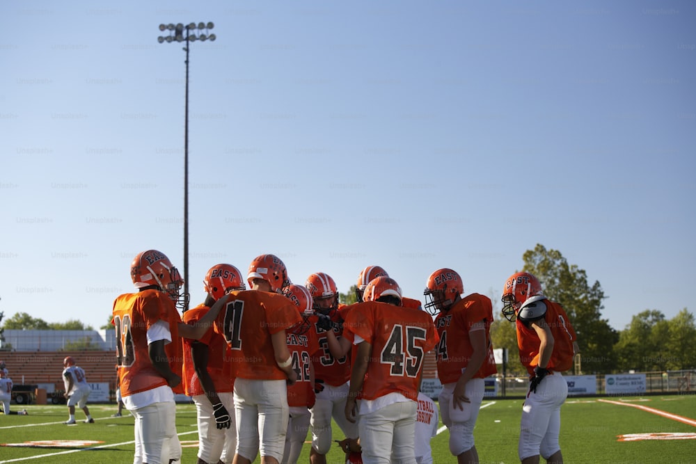 a group of young men standing on top of a football field