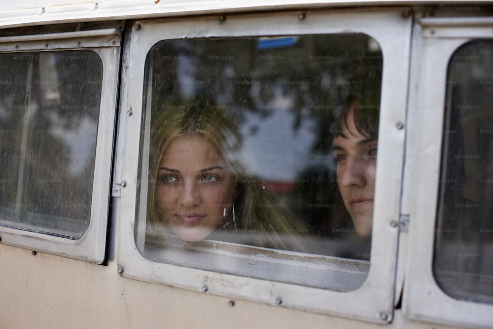 two women looking out the window of a bus
