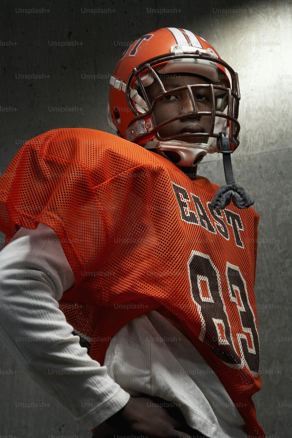 a football player wearing an orange jersey and helmet