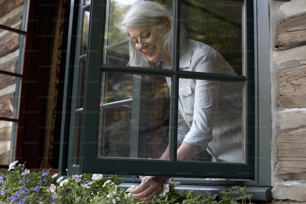 uma mulher mais velha olhando pela janela
