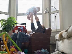 a man sitting in a chair holding a baby