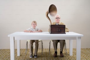 Un vieil homme et un jeune garçon assis à une table