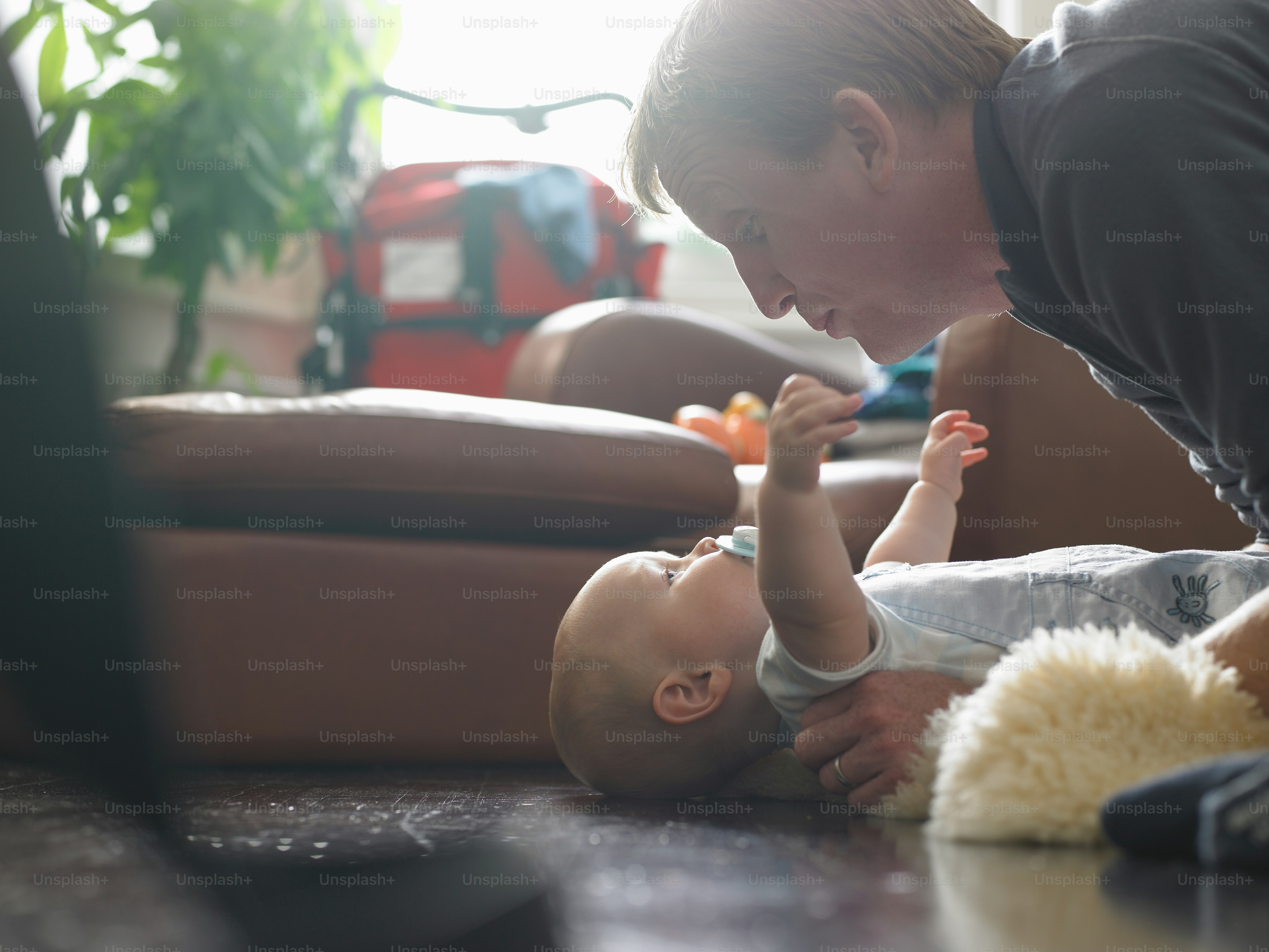 A woman playing with a baby on the floor photo – Photography Image on ...