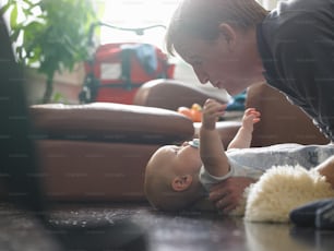 a woman playing with a baby on the floor