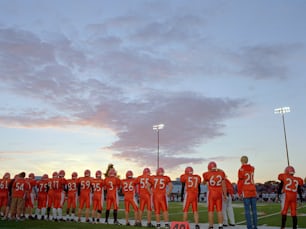 a group of football players standing on top of a field