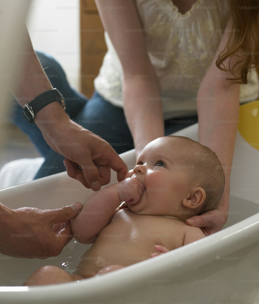 Ein Baby wird in einer Badewanne gebadet